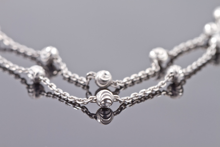 Elegant unusual silver chain on the reflecting surfaceの写真素材