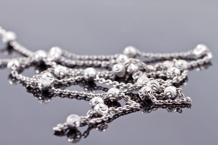 Elegant unusual silver chain on the reflecting surfaceの写真素材