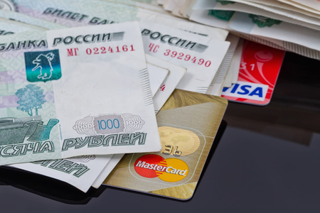 VOLGOGRAD - AUGUST 16: Plastic card payment systems Visa and MasterCard are with a bunch of Russian money . August 16, 2015 in Volgograd, Russia.のeditorial素材