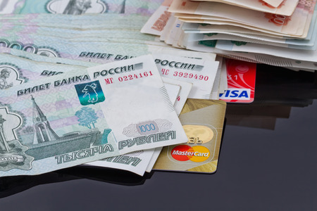VOLGOGRAD - AUGUST 16: Plastic card payment systems Visa and MasterCard are with a bunch of Russian money . August 16, 2015 in Volgograd, Russia.のeditorial素材