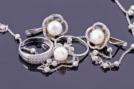 Fine silver rings are together with unusual silver chain on a white acrylic Boardの写真素材