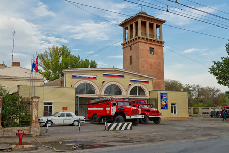 VOLGOGRAD - AUGUST 29: Fire trucks are in full readiness on the ground in front of the fire station with old fire tower. August 29, 2015 in Volgograd, Russia.のeditorial素材