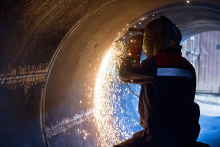 The welder carries out mechanical cleaning of the root surfaces of the weld seam to continue the...
