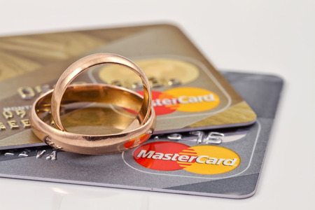 VOLGOGRAD - AUGUST 16: Gold wedding rings lie on a two credit cards payment system MasterCard gold  and  MasterCard silverのeditorial素材
