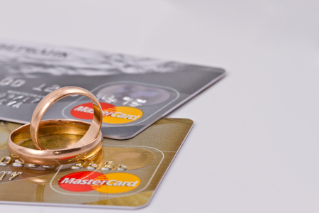 VOLGOGRAD - AUGUST 16: Gold wedding rings lie on a two credit cards payment system MasterCard gold  and  MasterCard silverのeditorial素材