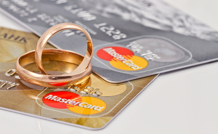 VOLGOGRAD - AUGUST 16: Gold wedding rings lie on a two credit cards payment system MasterCard gold  and  MasterCard silverのeditorial素材