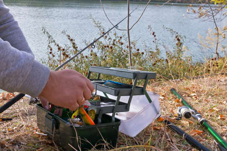 A fisherman picks bait for fishing on a spinning in a special boxの写真素材