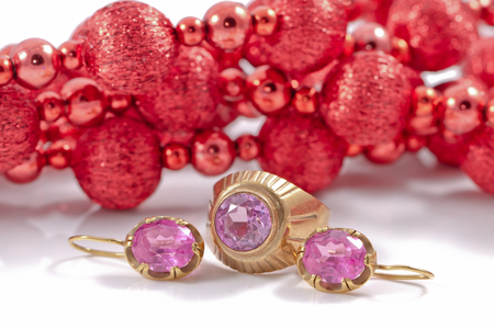 set of gold jewelry of earrings and ring with alexandrite on the background of Christmas decorationsの写真素材