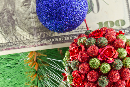 Beautiful Christmas ball in the shape of a bouquet and a hundred dollar bill hanging on the Christmas treeの写真素材