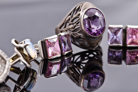Carved silver ring with a blue gem and a silver earrings with purple gemstonesの写真素材
