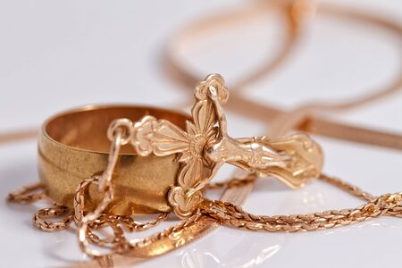 engagement gold ring old style and a gold cross on a chainの写真素材