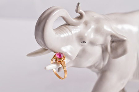 Porcelain statuette of an elephant holding the trunk of a gold ring with amethystの写真素材