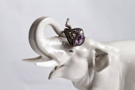 Porcelain statuette of an elephant holding the trunk of a silver ring with amethystの写真素材