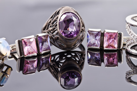 Carved silver ring with a blue gem and a silver earrings with purple gemstonesの写真素材