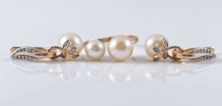 Gold set of ring and earrings in leaf shape with pearlの写真素材