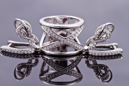 Elegant silver earrings in the shape of a horseshoe and a silver ring from the same setの写真素材