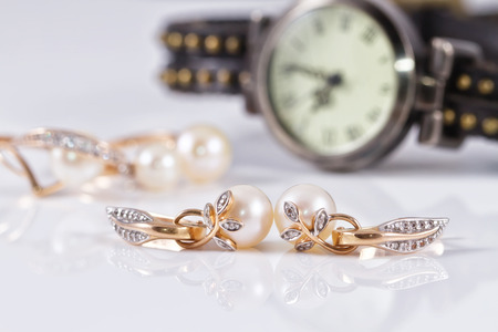 gold jewelry with pearls on a background of elegant women's watchesの写真素材