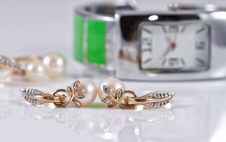 gold jewelry with pearls on a background of elegant women's watchesの写真素材