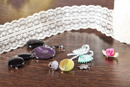 Buttons for garments of different shapes and colors lying on a wooden oak tableの写真素材