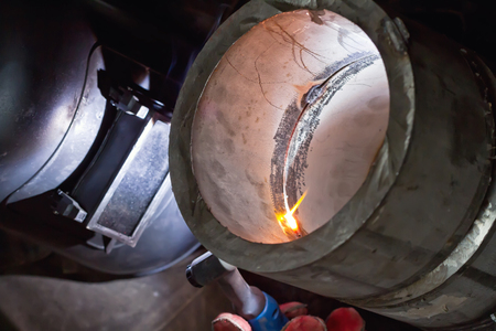 Welding control sample at 45 degrees from thick-walled stainless steel pipe by the method of argon arc weldingの写真素材