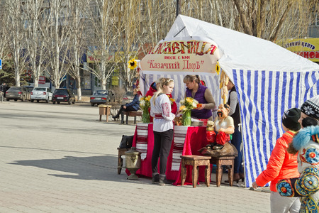 VOLGOGRAD - MARCH 12: Sale of hot pancakes and tea from a samovar out of the tent installed in the town square during the celebration of carnival . March 12, 2016 in Volgograd, Russia.のeditorial素材