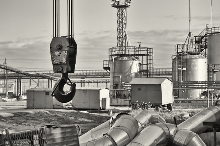 Dismantling work using crane on old refinery. Sepia