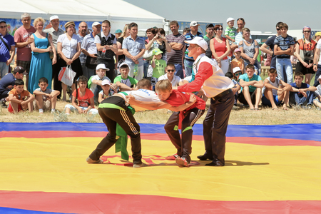 SMALL CHAPURNIKI, VOLGOGRAD, RUSSIA - MAY 24:Traditional Tatar belt wrestling Koresh, the tournament between the youth at the Sabantuy. May 24, 2014 in Volgograd, Russia.のeditorial素材