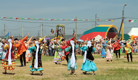 SMALL CHAPURNIKI, VOLGOGRAD, RUSSIA - MAY 24: Young boys and girls dressed in traditional costumes dancing folk dances at the celebration of the Sabantuy. May 24, 2014 in Volgograd, Russia.のeditorial素材