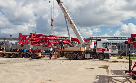 VOLGOGRAD - APRIL 28: Unloading sections of the boom of a large crawler crane using a crane on site of a petrochemical plant . April 28, 2016 in Volgograd, Russia.のeditorial素材