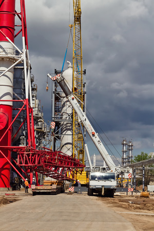 VOLGOGRAD - APRIL 28: Unloading sections of the boom of a large crawler crane using a crane on site of a petrochemical plant . April 28, 2016 in Volgograd, Russia.のeditorial素材