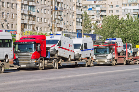 VOLGOGRAD - MAY 22:Transportation new cars of emergency services of ambulance and police cars on the trucks. May 22, 2016 in Volgograd, Russia.のeditorial素材