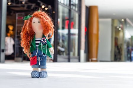 handmade doll with curly red hair walks in the Mallの写真素材