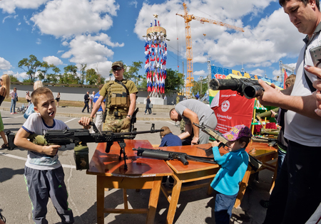 VOLGOGRAD - SEPTEMBER 10: The boy takes aim with a machine gun at the exhibition of firearms DOSAAF of Russia under the open sky. September 10, 2016 in Volgograd, Russia.のeditorial素材