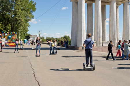 VOLGOGRAD - SEPTEMBER 10: Young people riding a Segway and gyrometer on the asphalt on the Central promenade of the city. September 10, 2016 in Volgograd, Russia.のeditorial素材