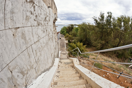Old stairs with cracked, uneven concrete stairs goes downの写真素材