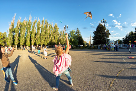 VOLGOGRAD - SEPTEMBER 9:  The little girl launches a kite during the festival in the open air. September 9, 2016 in Volgograd, Russia.のeditorial素材
