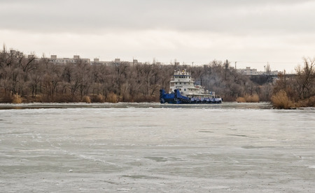 VOLGOGRAD, RUSSIA - NOVEMBER 27: River tug floats on the navigable channel is already fettered by ice. November 27, 2016 in Volgograd, Russia.のeditorial素材
