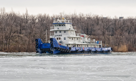 VOLGOGRAD, RUSSIA - NOVEMBER 27: River tug floats on the navigable channel is already fettered by ice. November 27, 2016 in Volgograd, Russia.のeditorial素材