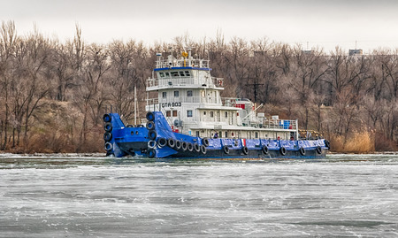 VOLGOGRAD, RUSSIA - NOVEMBER 27: River tug floats on the navigable channel is already fettered by ice. November 27, 2016 in Volgograd, Russia.のeditorial素材