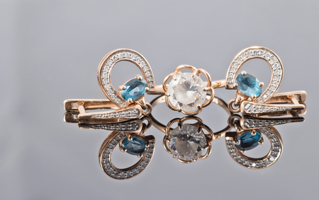 Gold earrings in the shape of a horseshoe adorned with Topaz stones and golden ring with diamondの写真素材