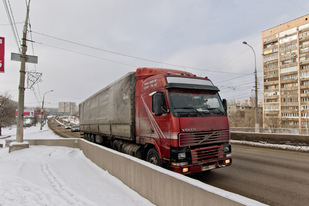 VOLGOGRAD - JANUARY 29: The truck trailer is raised up on a bridge on a snowy dirt road. January 29, 2017 in Volgograd, Russia.のeditorial素材
