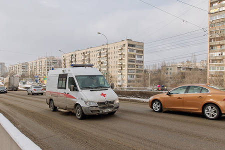VOLGOGRAD - JANUARY 29: Ambulance based on a Mercedes van in a hurry to call on the cleared snow from the bridge. January 29, 2017 in Volgograd, Russia.のeditorial素材