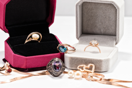 A variety of jewelry scattered near gift boxes with gold ringsの写真素材