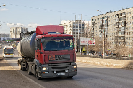 VOLGOGRAD - MARCH 5: A truck with a tank for transportation of petroleum products rises on the bridge. March 5, 2017 in Volgograd, Russia.のeditorial素材