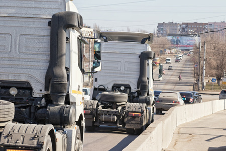 VOLGOGRAD - MARCH 5: Trucks tractors without trailers down from the bridge into the stream of urban transport. March 5, 2017 in Volgograd, Russia.のeditorial素材