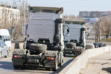VOLGOGRAD - MARCH 5: Trucks tractors without trailers down from the bridge into the stream of urban transport. March 5, 2017 in Volgograd, Russia.のeditorial素材