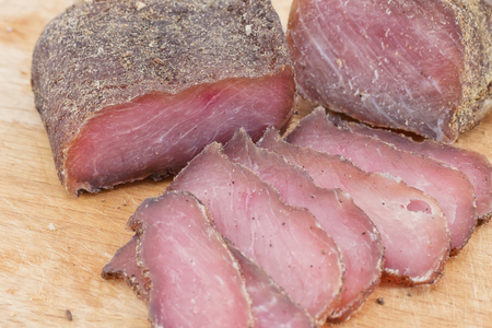 Delicious jerky at home meat with spices with cumin sliced on a wooden Boardの写真素材