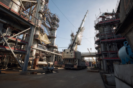 Automotive heavy lift crane is unfolded with an extended boom on the installation of a chemical plant at the time of repairの写真素材
