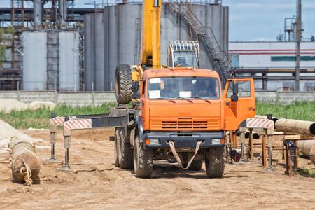 Construction work on the pipe laying of the pipeline into the trench using a craneの写真素材