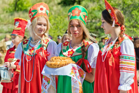 VOLGOGRAD - MAY 29: Three girls in Russian folk costumes is waiting for the guests with traditional bread and salt. May 29, 2017 in Volgograd, Russia.のeditorial素材